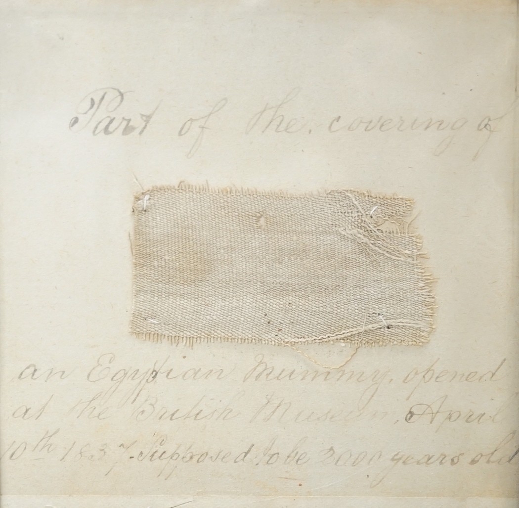 A small 19th century framed textile fragment, mounted with handwritten script; “part of the covering of an Egyptian Mummy opened at the British Museum April 10th 1837, supposed to be 2000 years old”, 21cms wide x 22cms h